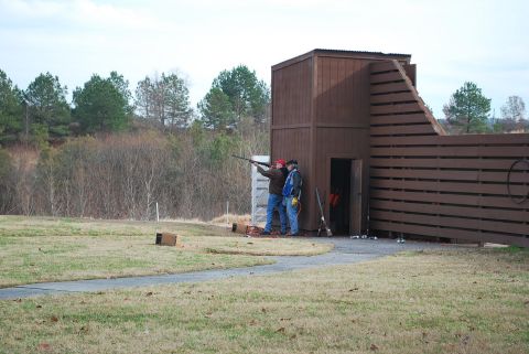 1979 Ford F-150 - Two men are practicing clay shooting at a range with a wooden structure in the background.