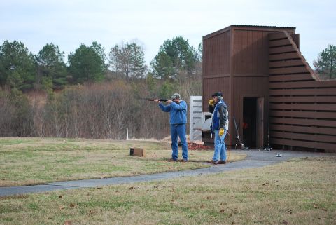 1979 Ford F-150 - Two men participate in a clay pigeon shooting event at an outdoor range.