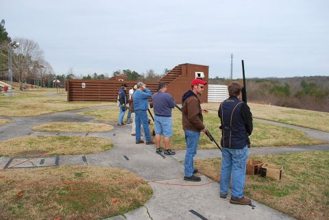 1979 Ford F-150 - People participate in a clay shooting event at an outdoor range, with targets and a wooded area in the background.