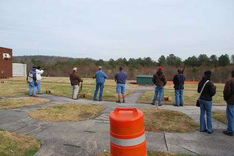 1979 Ford F-150 - A group of people are gathered at a shooting range, with one individual taking aim.