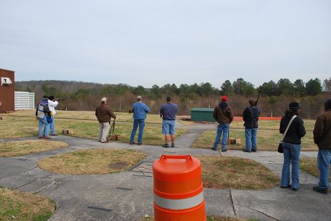 1979 Ford F-150 - People are practicing skeet shooting at an outdoor range on an overcast day.