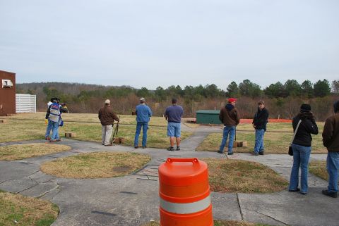 1979 Ford F-150 - A group of people are gathered at an outdoor shooting range on an overcast day.