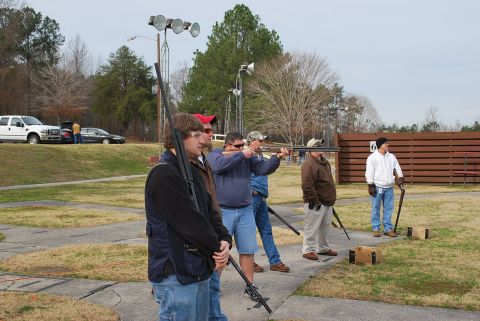 1979 Ford F-150 - A group of people are participating in a shooting sport at an outdoor range.
