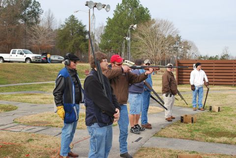 1979 Ford F-150 - A group of people are participating in a skeet shooting event at an outdoor range.