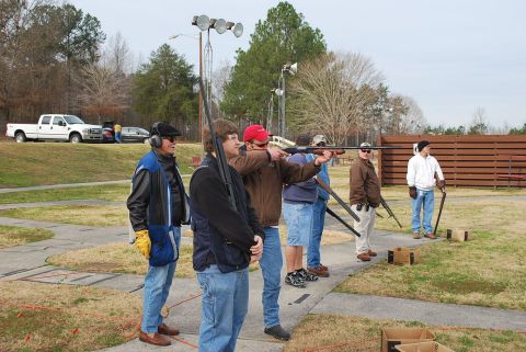 1979 Ford F-150 - Several people are practicing shooting at a clay pigeon range on a clear day.