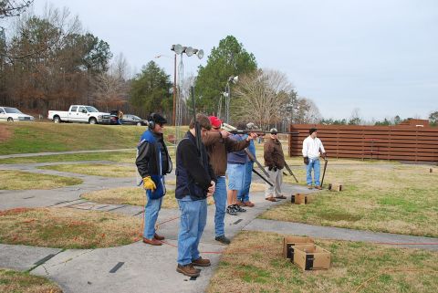 1979 Ford F-150 - People participate in skeet shooting at an outdoor range on a cloudy day.