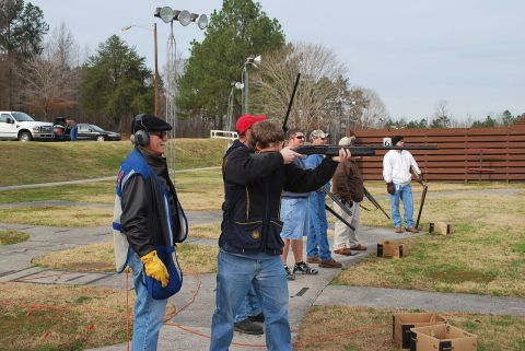 1979 Ford F-150 - Several individuals are engaged in clay pigeon shooting practice at an outdoor range, with instructors and spectators present.