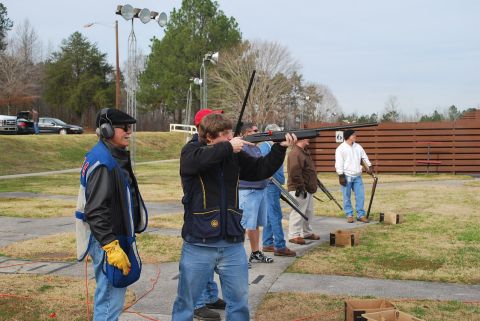 1979 Ford F-150 - Several individuals are participating in a shotgun shooting event at an outdoor range.