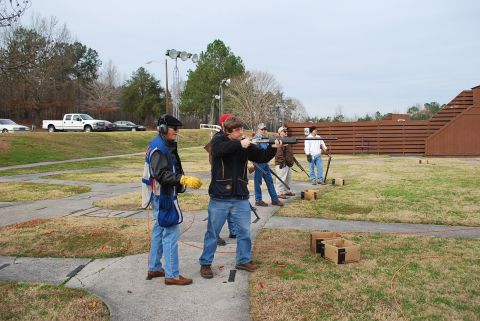 1979 Ford F-150 - People practice shooting clay pigeons at an outdoor range on an overcast day.