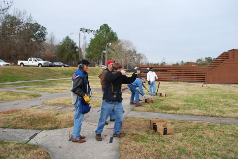 1979 Ford F-150 - A group of people participate in a clay pigeon shooting event at an outdoor range.