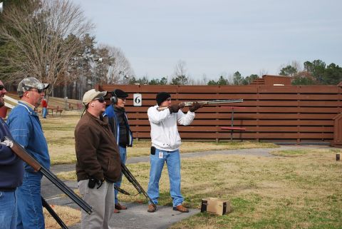 1979 Ford F-150 - Men practice shooting at a clay pigeon range on a cloudy day.