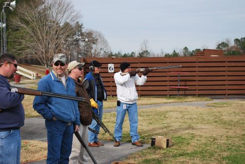 1979 Ford F-150 - A group of men are at a clay shooting range, with one person aiming a shotgun.