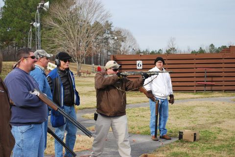 1979 Ford F-150 - Several individuals are engaged in clay pigeon shooting at an outdoor range, with one person aiming a shotgun.