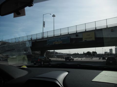 1991 Ford Bronco - Vehicles drive on a highway under an overpass with an "International Border 500 FEET" sign.
