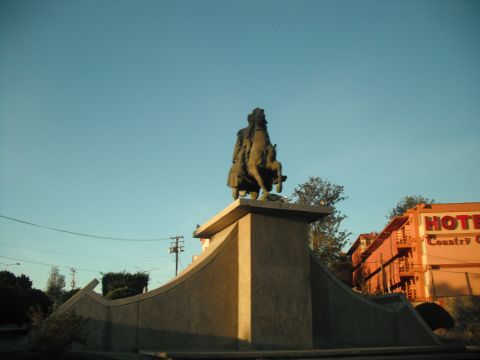 1991 Ford Bronco - A statue of a person on horseback stands before a hotel building under a clear blue sky.