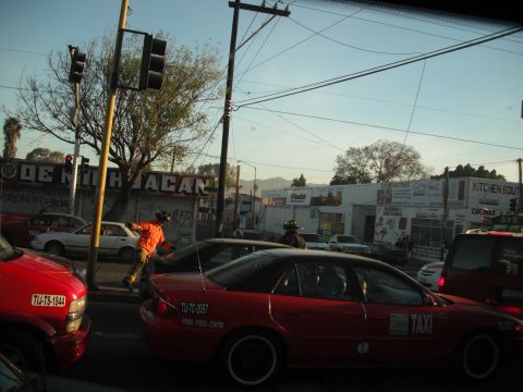 1991 Ford Bronco - Traffic scene with multiple vehicles and pedestrians on a sunny day.