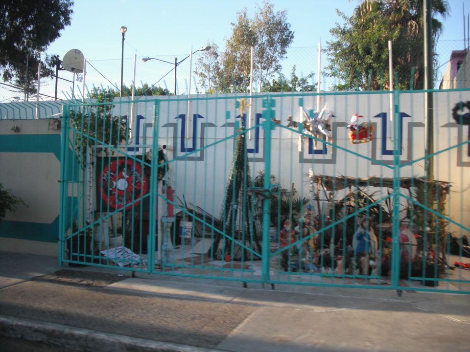 Gate with Christmas decorations, including a nativity scene and a piñata