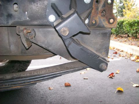 1989 Ford Bronco - Close-up of a vehicle's rear suspension components, including a leaf spring and mounting bracket.