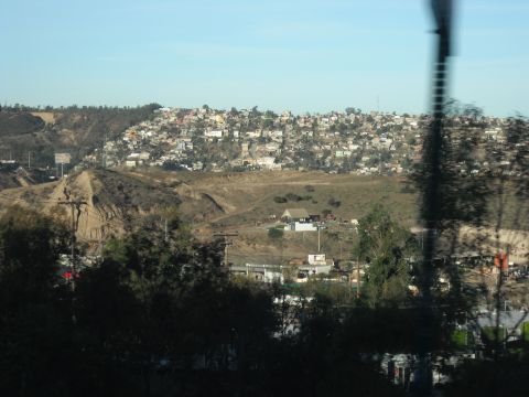 1991 Ford Bronco - A hillside community is visible under a clear blue sky, with some structures in the foreground.