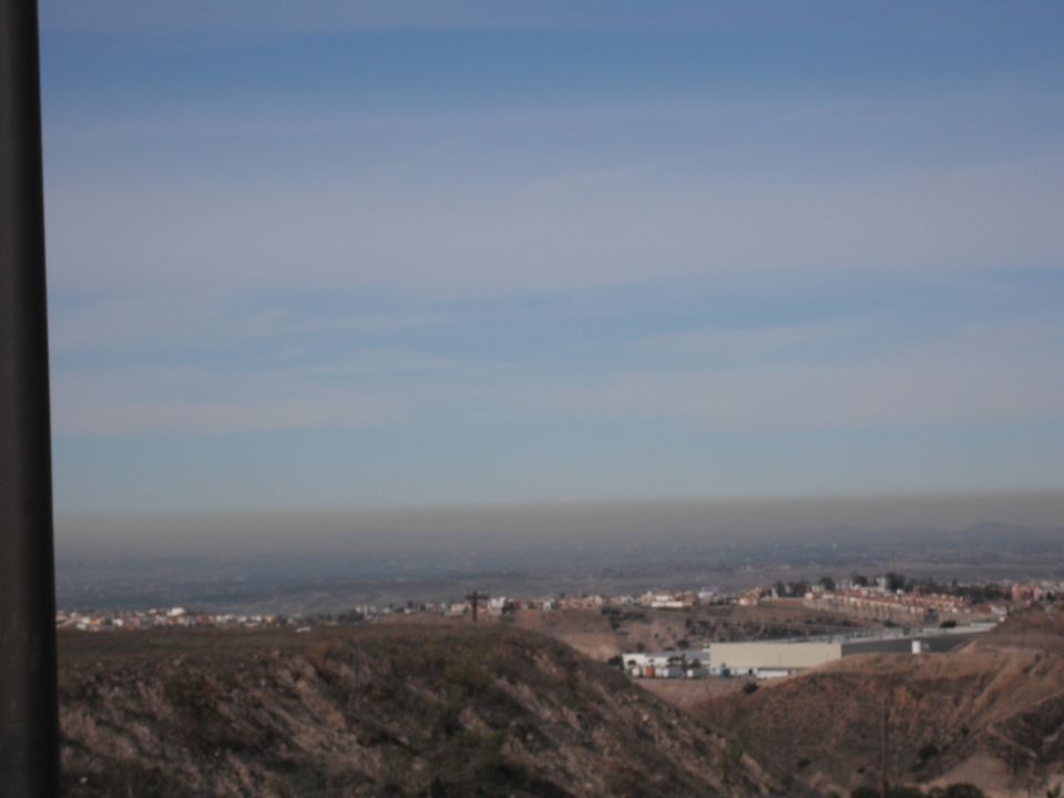 Distant landscape with hills and buildings under a hazy sky