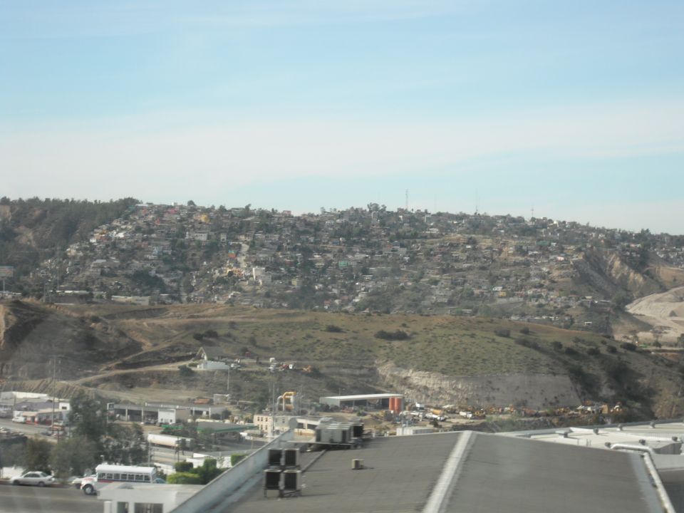 Overhead view of a hillside community with buildings and roads below