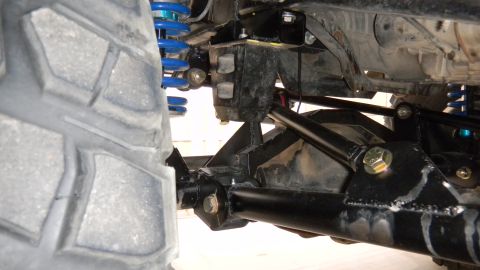 1997 Ford Ranger - Custom suspension modifications with large off-road tire and blue shock absorbers visible.