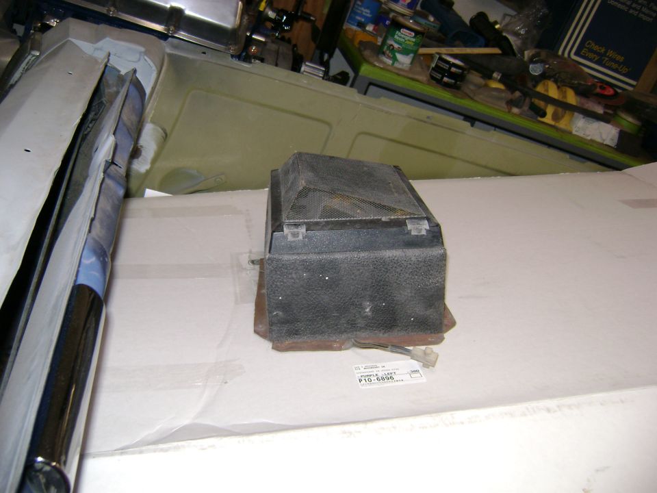 Black plastic automotive component box on a shop counter with parts label