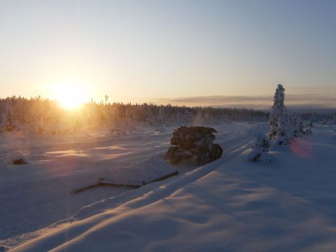 2000 Ford E350 - A snowmobile travels across a snow-covered terrain during a winter sunset.