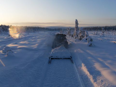 2000 Ford E350 - A snowmobile plows through a snow-covered trail in a frozen, wooded area.