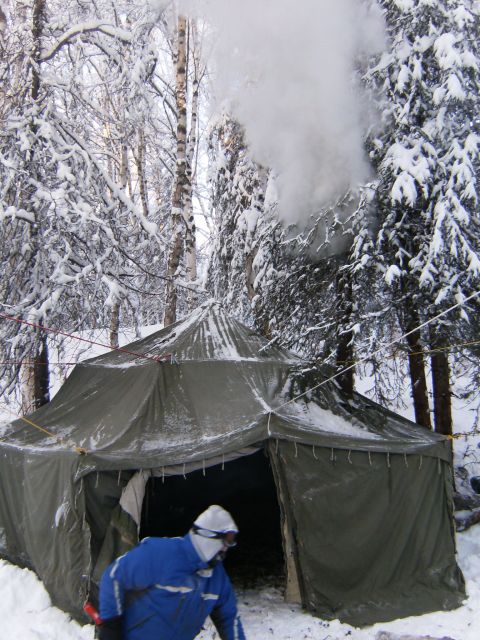 2000 Ford E350 - A person in a blue jacket approaches a tent set up in a snowy woodland area.