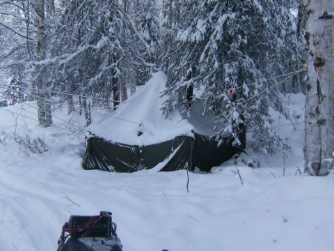 2000 Ford E350 - Winter camping scene with a tent pitched in a snowy forest environment.