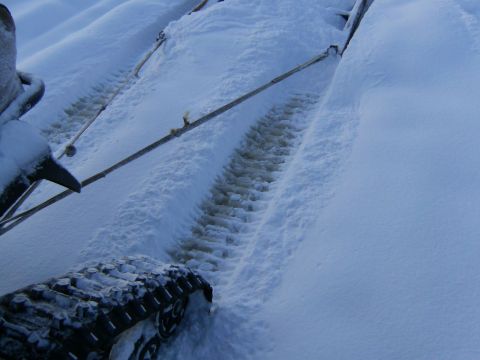 2000 Ford E350 - Tracks from a snowmobile are visible in the snow, with tow ropes attached.
