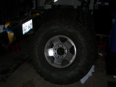 1991 Jeep Wrangler - A large tire and wheel assembly is shown, with a license plate in the background.