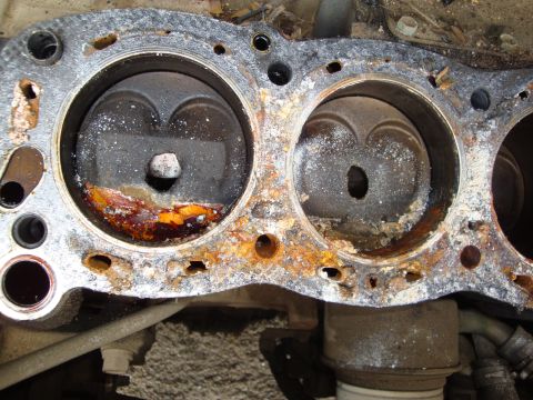 1990 Ford Taurus - Close-up view of a heavily corroded engine cylinder head, showing significant damage to the internal components.