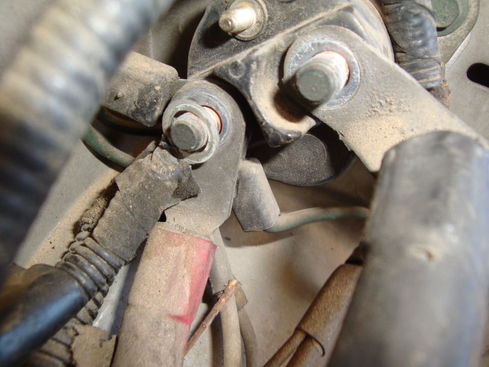 Close-up of a bolted electrical connection with wires and a red insulator