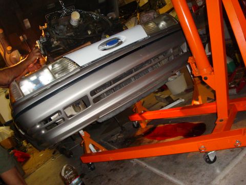 1990 Ford Taurus - Engine removal in progress for a 1990 Ford Taurus, supported by jack stands.