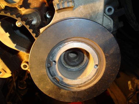 1990 Ford Taurus - This is a close-up view of a vehicle's engine crankshaft pulley and timing belt system.