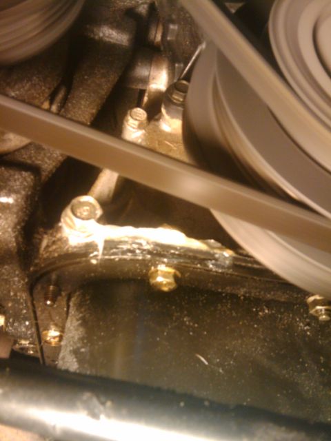 1993 Ford Bronco - This image shows a close-up view of an engine's oil pan, highlighting the gasket and surrounding bolts.