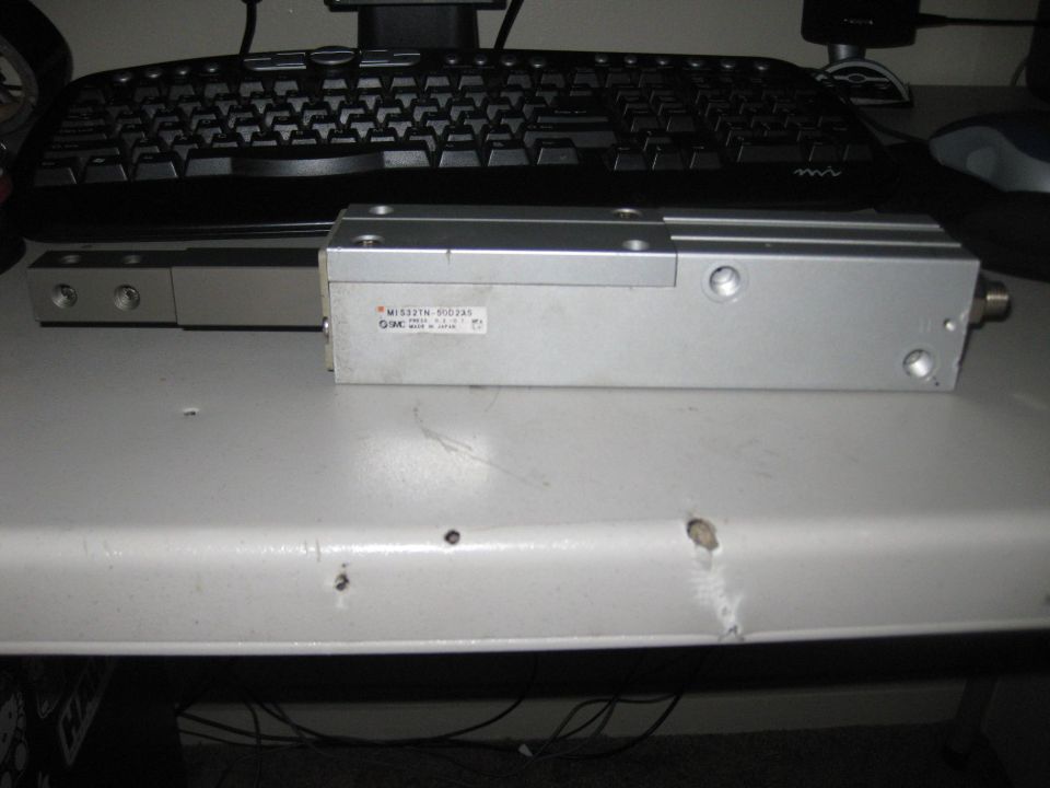 Aluminum SMC pneumatic slide actuator MIS32TN-500 on a desk in front of a keyboard