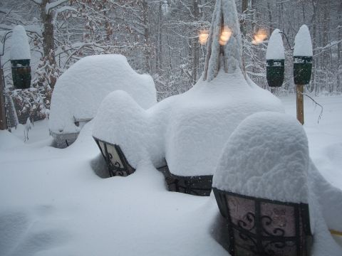 1971 Ford Ranchero - Deep fresh snow buries a row of patio furniture and wrought-iron lanterns in a wooded yard, leaving only rounded white mounds; a lit lamp p…