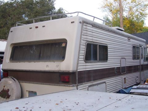 1974 Dodge RV/Conversion Chassis - This motorhome has a large rear window and a roof rack, with a spare tire visible.