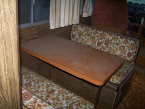 1974 Dodge RV/Conversion Chassis - Interior view of an RV dinette area floral patterned seating and a wooden table.