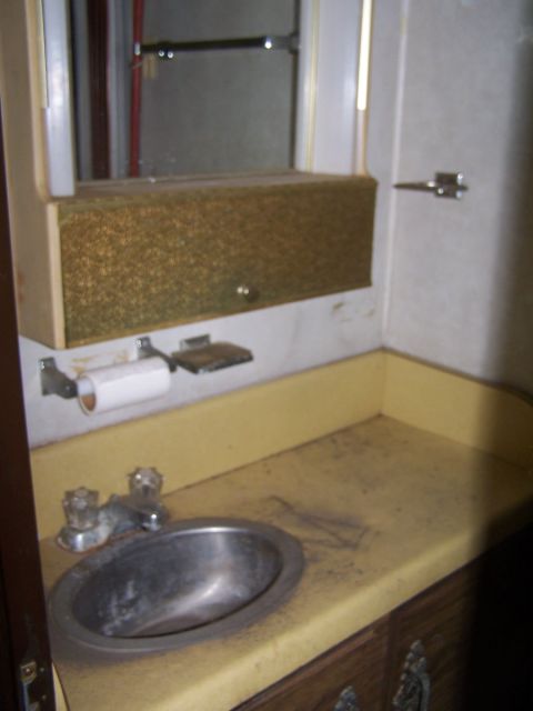 1974 Dodge RV/Conversion Chassis - Interior view of an RV bathroom sink area with a vanity and mirror.