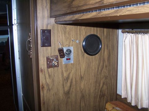 1974 Dodge RV/Conversion Chassis - Interior view of a motorhome wood paneling, a gauge, a speaker, and a light switch.