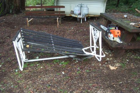 1994 Ford F-150 - A Stihl chainsaw rests on a picnic table near a broken bench and propane tanks in a wooded area.