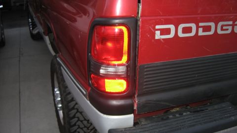 1997 Dodge 2500 - Close-up of a red Dodge pickup truck's rear, showing the taillight and part of the tailgate.