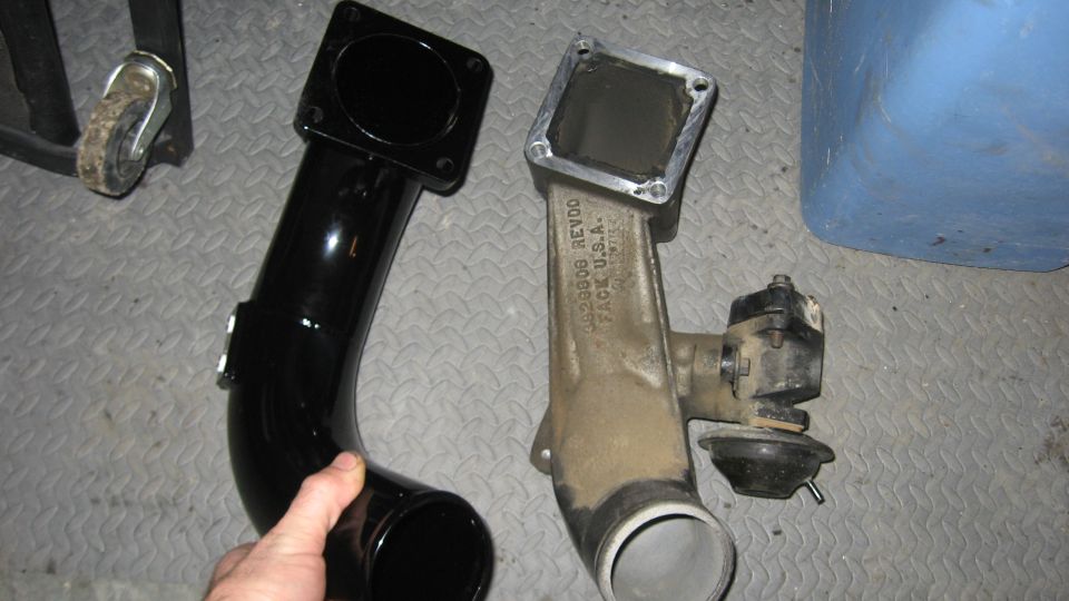 Black intake pipe next to a dirty metal intake manifold with a vacuum actuator