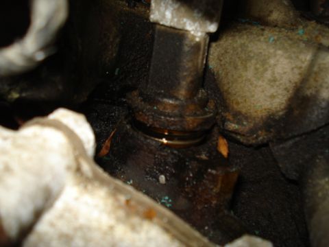 1991 Ford Bronco - Engine part showing an oil leak, likely from a seal or gasket.