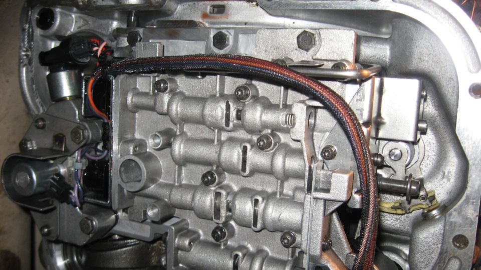 Close-up of an automatic transmission valve body with solenoids and wiring