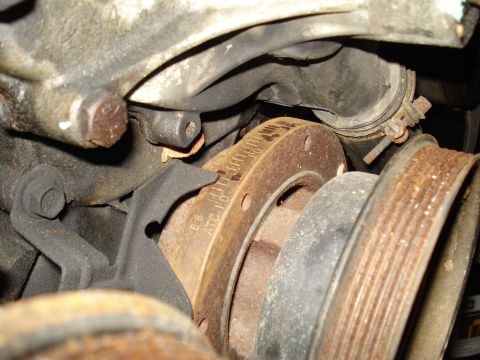 1991 Ford Bronco - Close-up of engine components, including a pulley with visible timing marks and signs of corrosion.